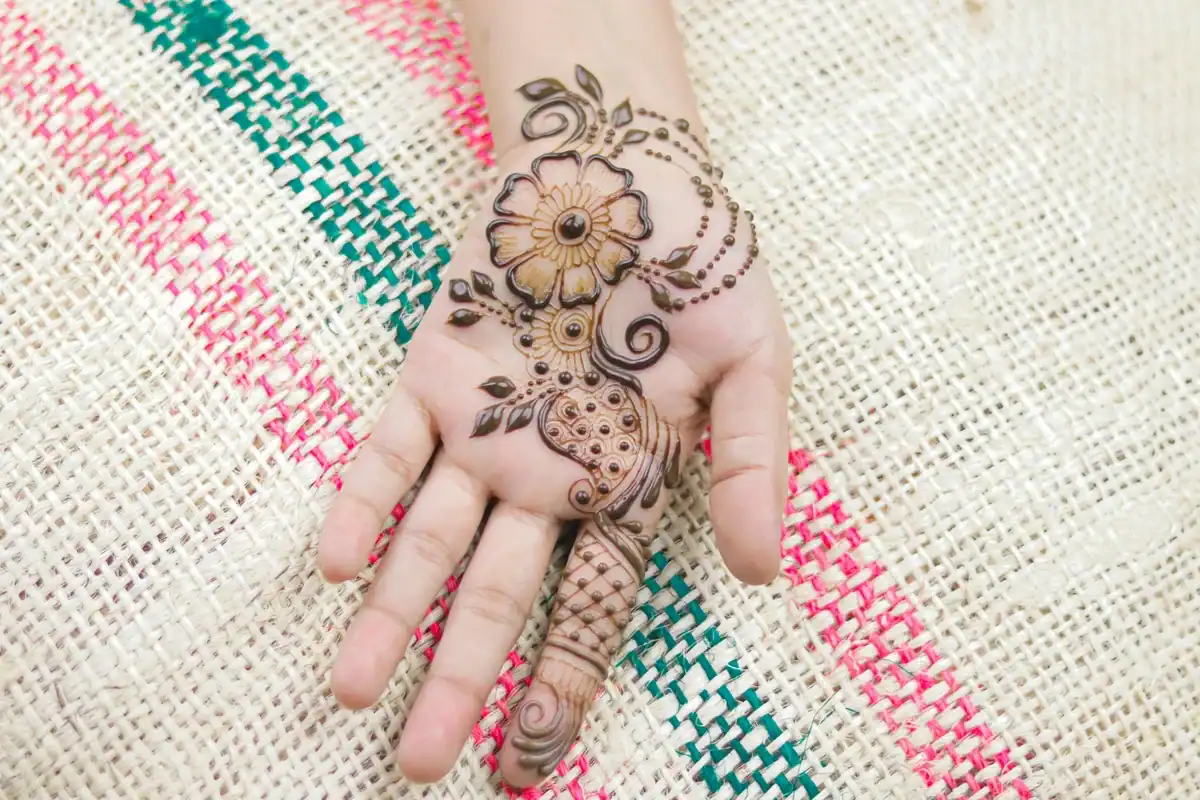 Arabic mehndi design with a lotus anchor and diamond lattice finger on the back hand mymehndidesigns.com