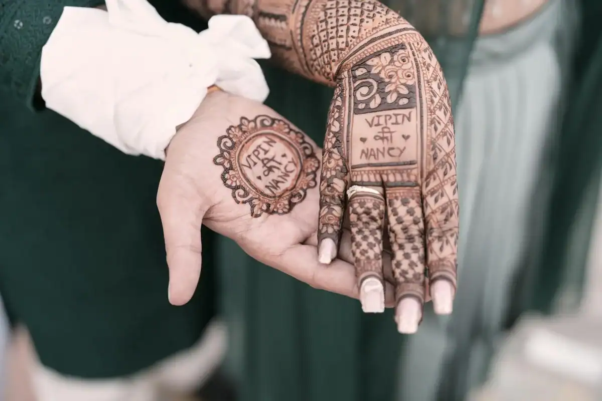 Royal Indian bridal mehndi design on full hand featuring geometric jaal lattice and name mandala with Om symbol